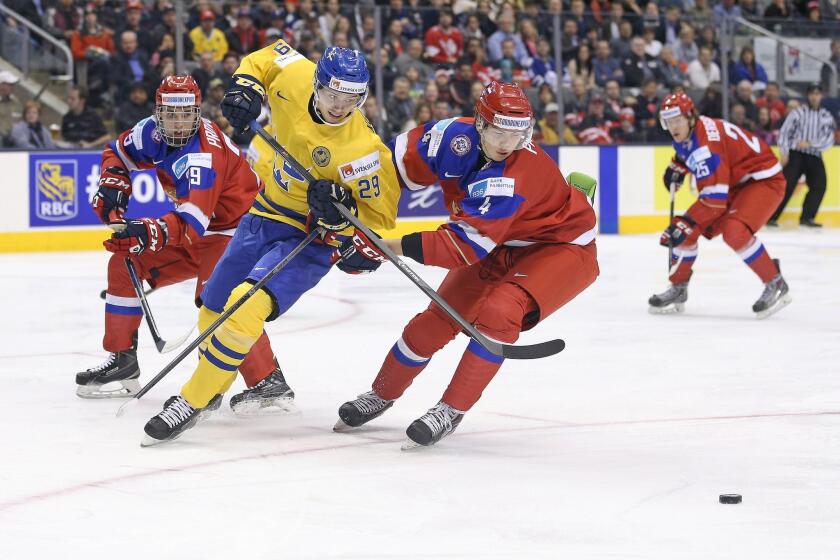 Sweden's Adrian Kempe, left, the Kings' top draft pick in June, skates against Russia's Ziat Paigin at Toronto's Air Canada Center on Dec 29.