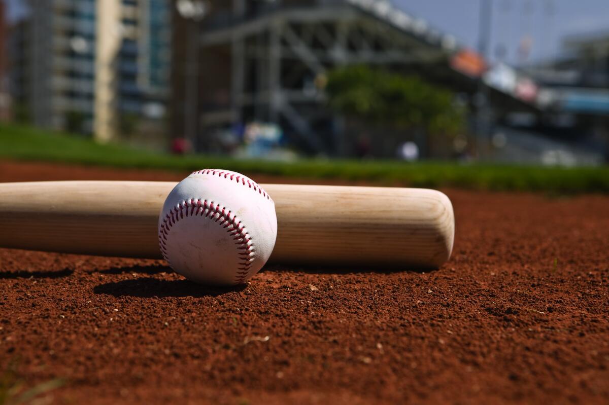 Baseball and bat on a ballfield.