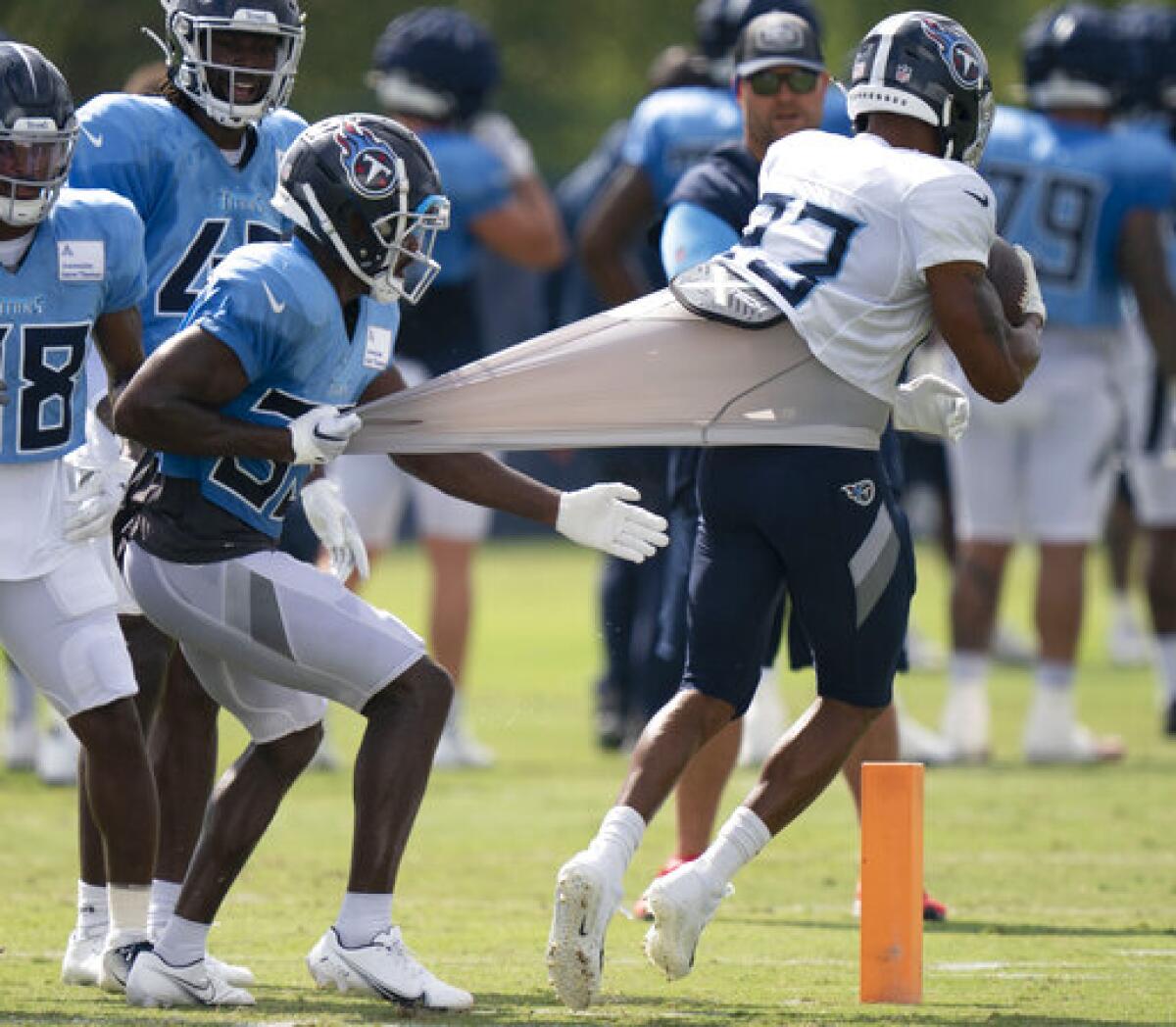 Tennessee Titans safety A.J. Moore Jr. (33) pulls on running back Trenton Cannon's (23) jersey during during an NFL football practice in Nashville, Tenn., Monday, Aug. 15, 2022. (George Walker IV/The Tennessean via AP)