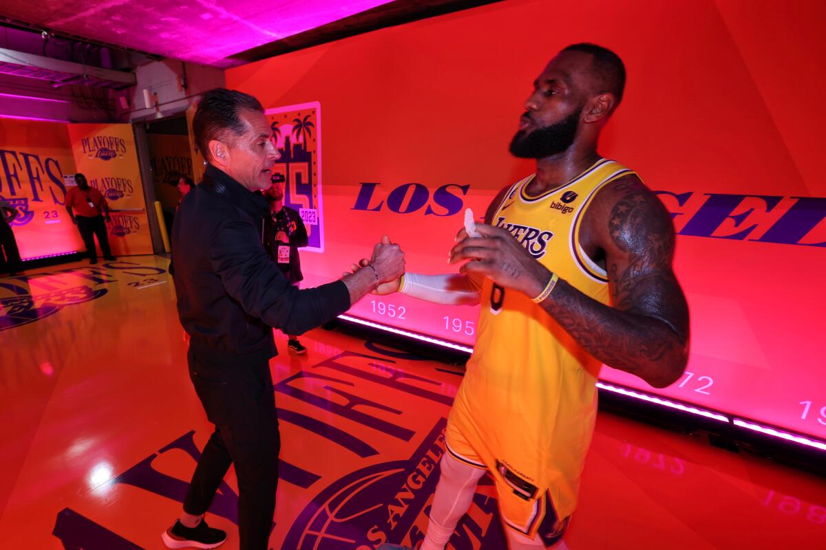 Lakers vice president of basketball operations Rob Pelinka, left, greets LeBron James.