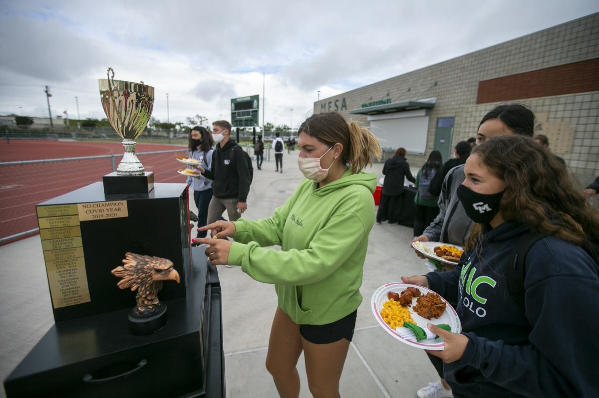 Chloe Fairchild, left, looks at the All-Sports Cup trophy during the lunch at Costa Mesa High School on Monday.