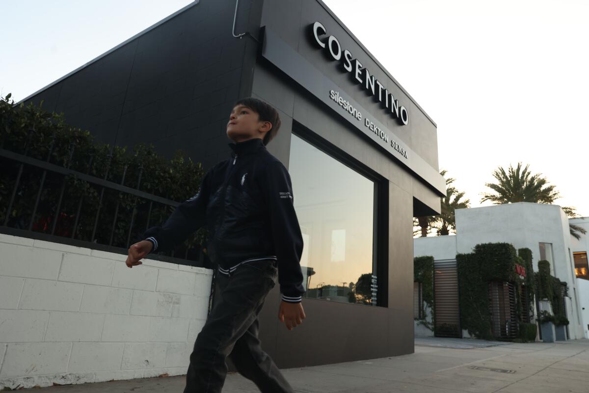 A boy walks by a Cosentino store 