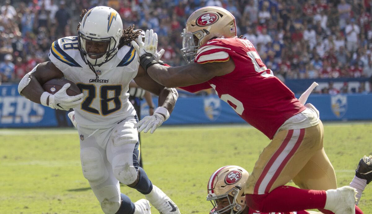 Chargers running back Melvin Gordon gets pushed out of bounds by 49ers linebacker Rueben Foster during first half Sunday.