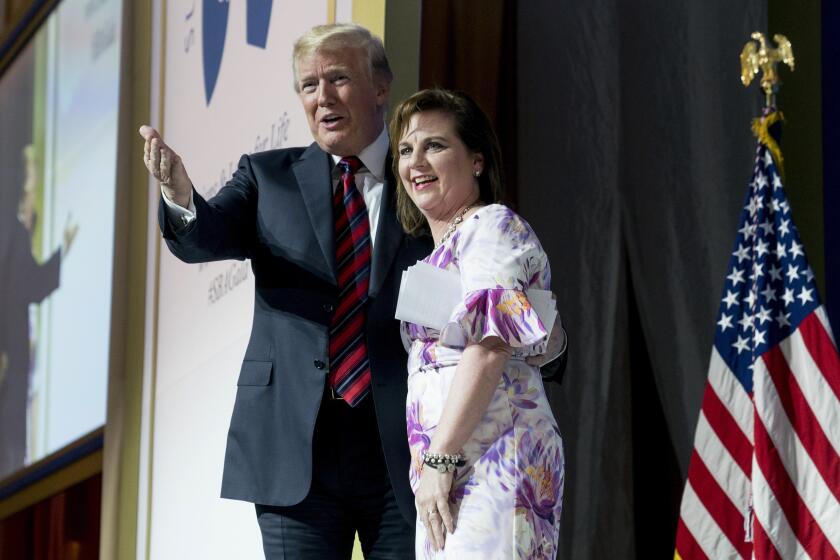 FILE - In this May 22, 2018 file photo, Susan B. Anthony List President Marjorie Dannenfelser, right, stands on state with President Donald Trump at the Susan B. Anthony List 11th Annual Campaign for Life Gala at the National Building Museum in Washington. Even as many religious organizations, from liberal to conservative, denounced the Trump administration's policy of separating immigrant families at the U.S.-Mexico border, some major advocacy groups that depict themselves as “pro-family” declined to join in the criticism. "We refrain from public comment on immigration and many other topics, including other policies that impact families," said Dannenfelser.(AP Photo/Andrew Harnik, File)