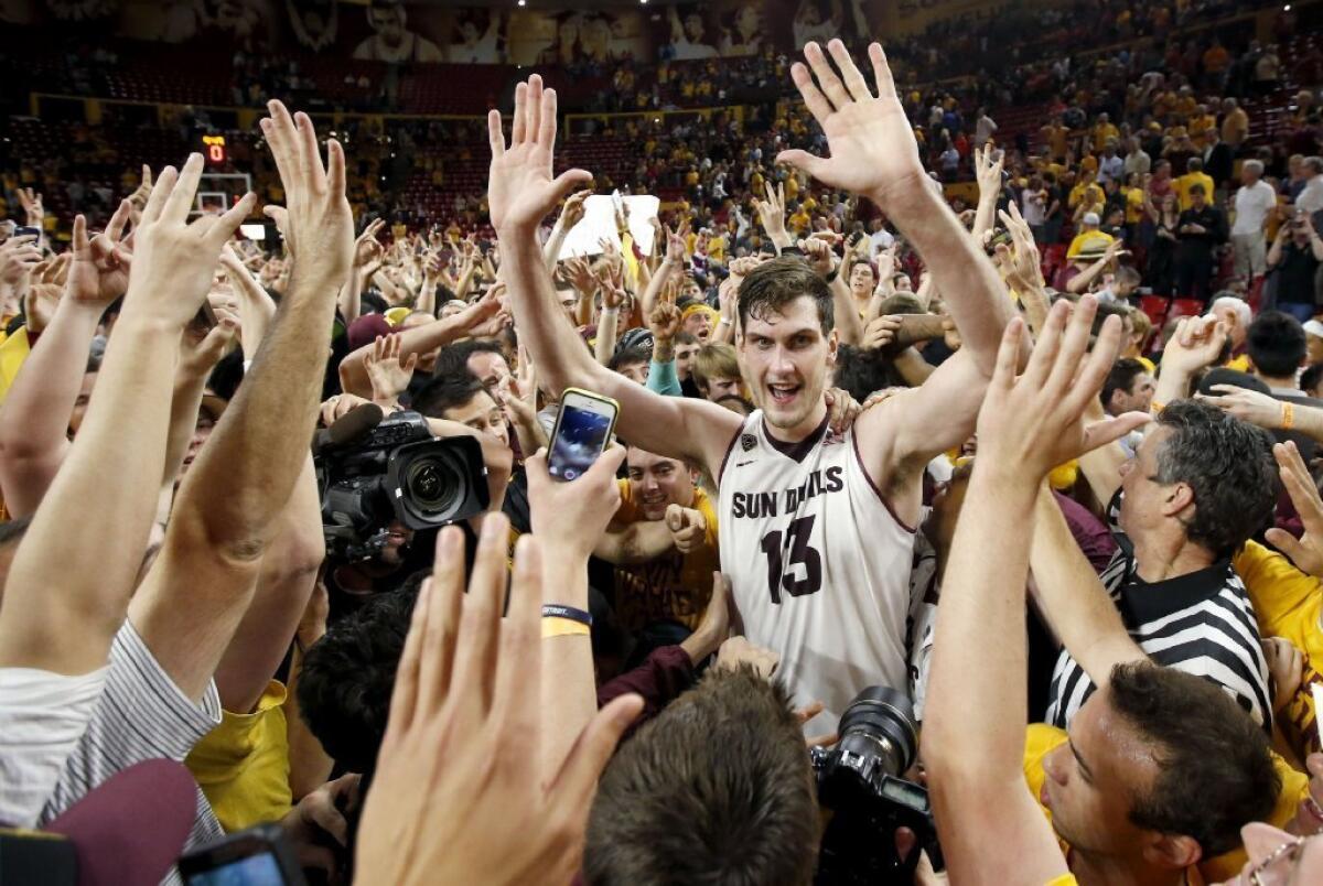 Arizona State's Jordan Bachynski is surrounded by fans after a 69-66 win over Arizona on Friday.