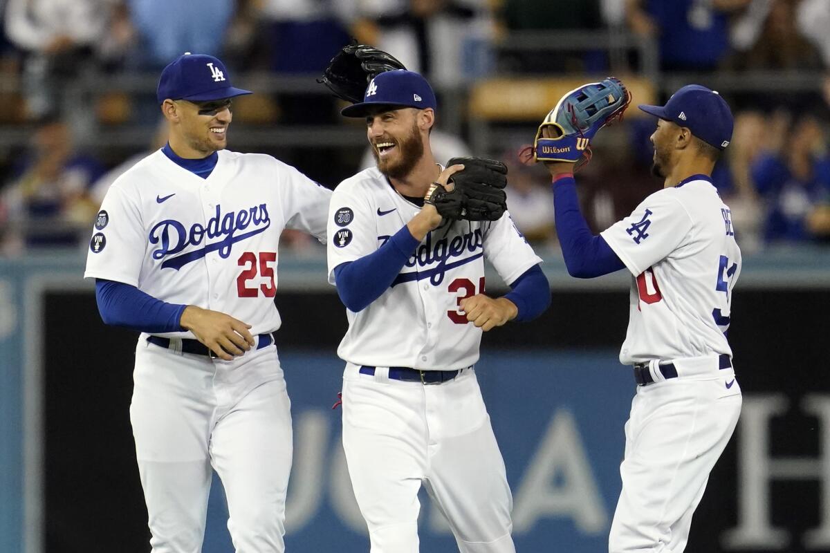 Dodgers outfielders Trayce Thompson, left, Cody Bellinger, center, and Mookie Betts celebrate a win over Colorado.