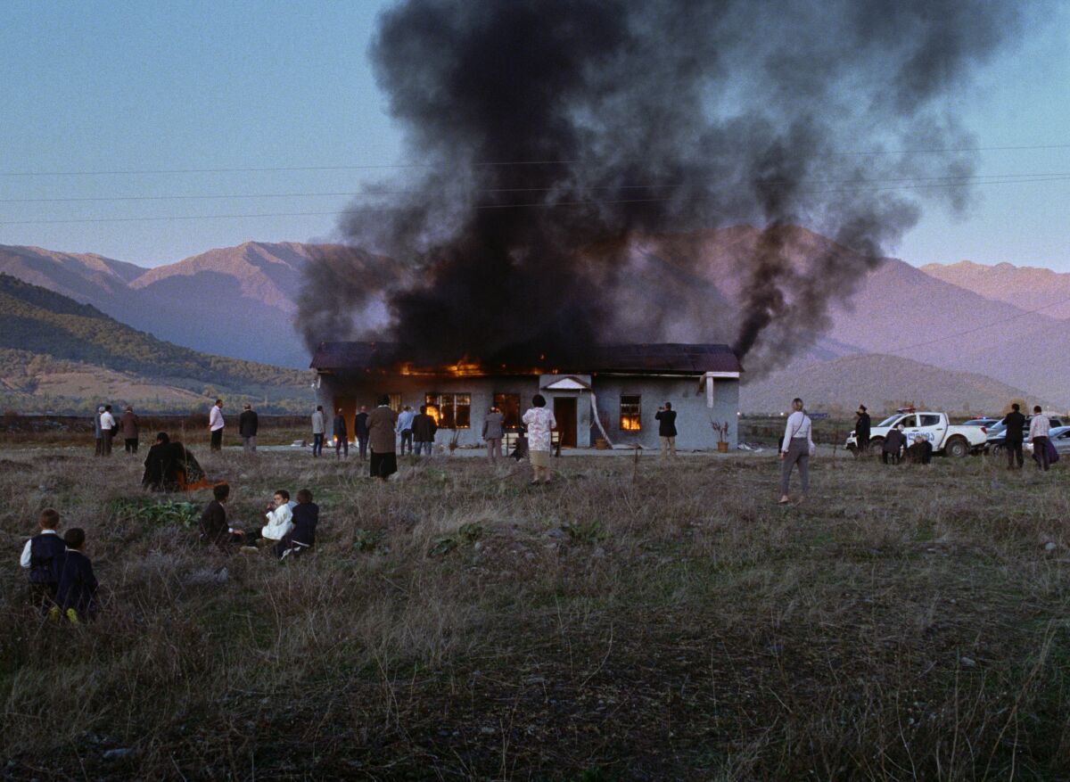 A structure burns in a still from the movie "Beginning."