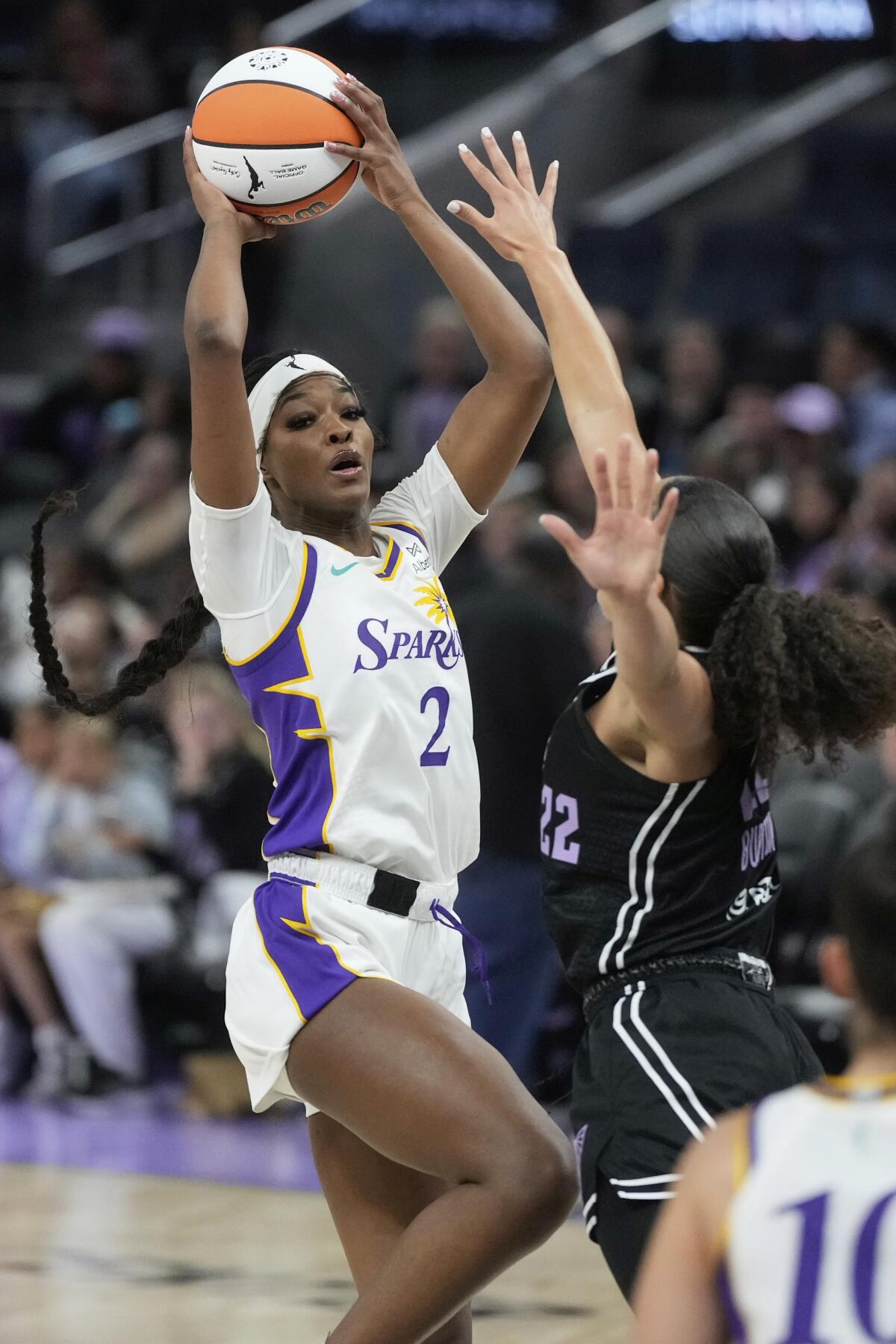 Sparks forward Rickea Jackson, left, looks to pass the ball after driving the down the lane and elevating against a defender.