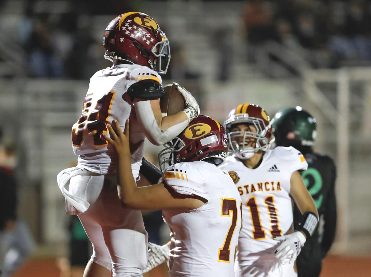 Estancia's Lucas Pacheco (34) is congratulated by teammates after scoring a touchdown against Costa Mesa on Friday night.