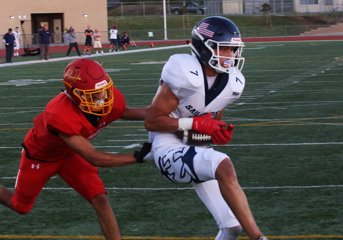 Austin Muro of Newport Harbor catches a 13-yard touchdown pass from Cole Lavin during the first quarter against Woodbridge in Friday's season opener at University High in Irvine.