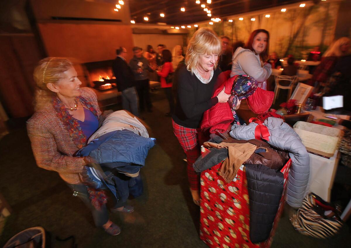 Costa Mesa Mayor Katrina Foley arranges a box full of coats and winter jackets during her annual Holiday Soiree. Donations can be dropped off at select locations until Dec. 16.