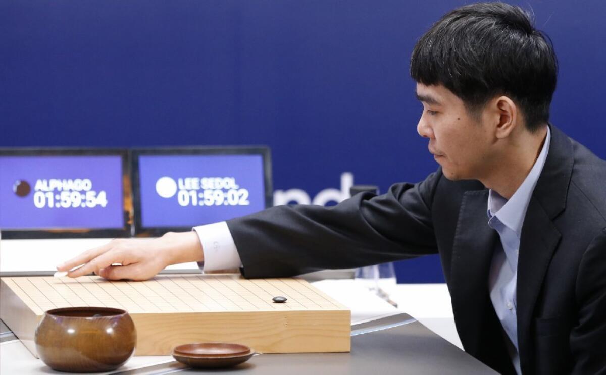 South Korean Go player Lee Sedol places the first stone against Google's artificial intelligence program, AlphaGo. Sunday in Seoul.