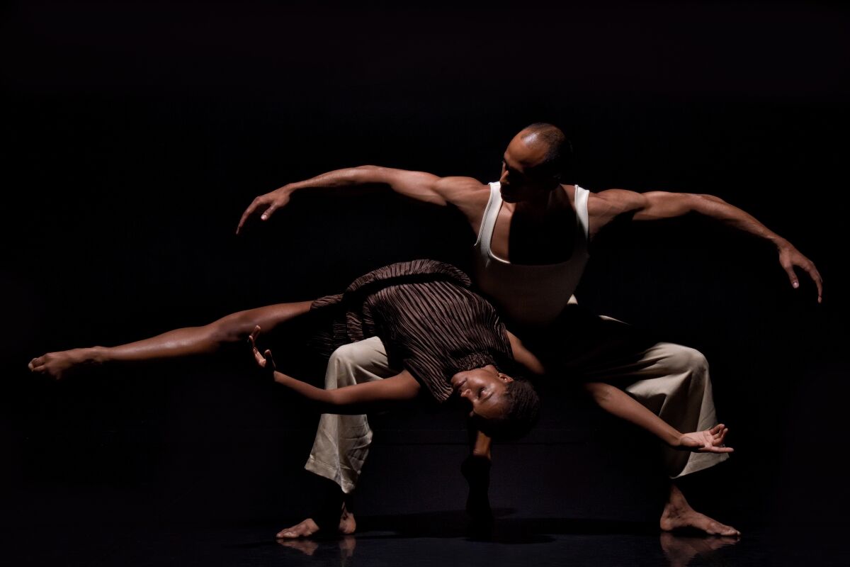 Two people dance and intertwine onstage