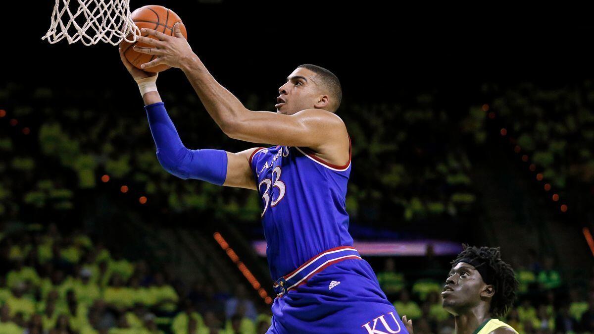 Kansas forward Landen Lucas (33) gets past Baylor's Johnathan Motley, right, for a shot in the first half Saturday.