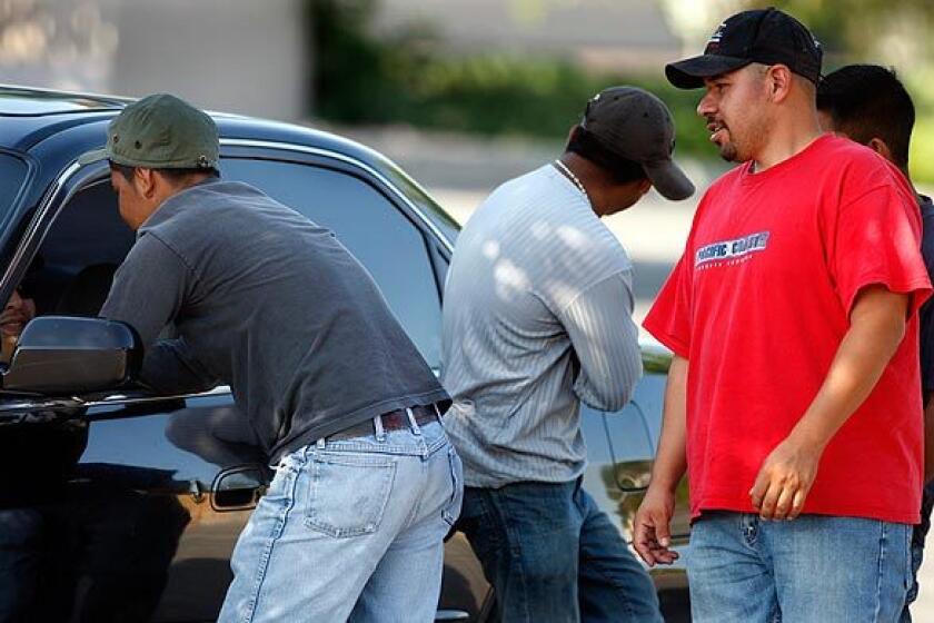 Day laborers looking for work approach a potential employer in the parking lot of a Riverside Home Depot. Regulars at the Home Depot say immigration raids and the dwindling need for labor have reduced their numbers from than 100 to about a dozen.