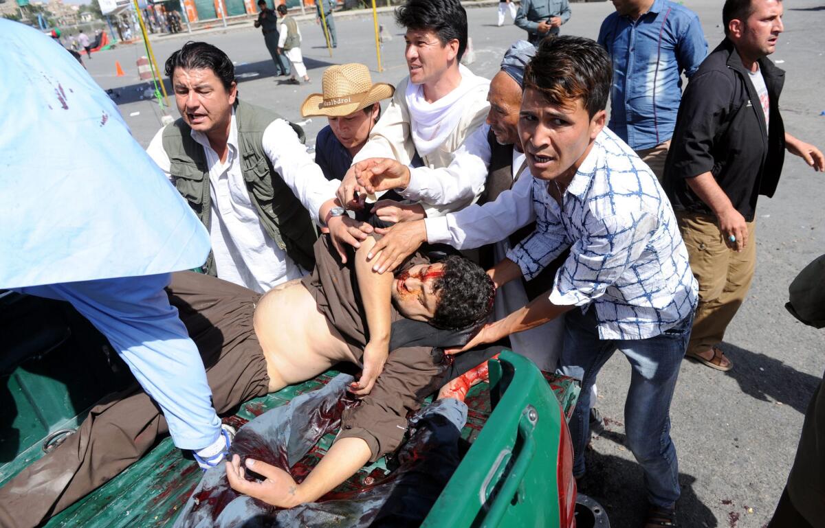 People transport victims' bodies after a suicide bomb attack in Kabul.