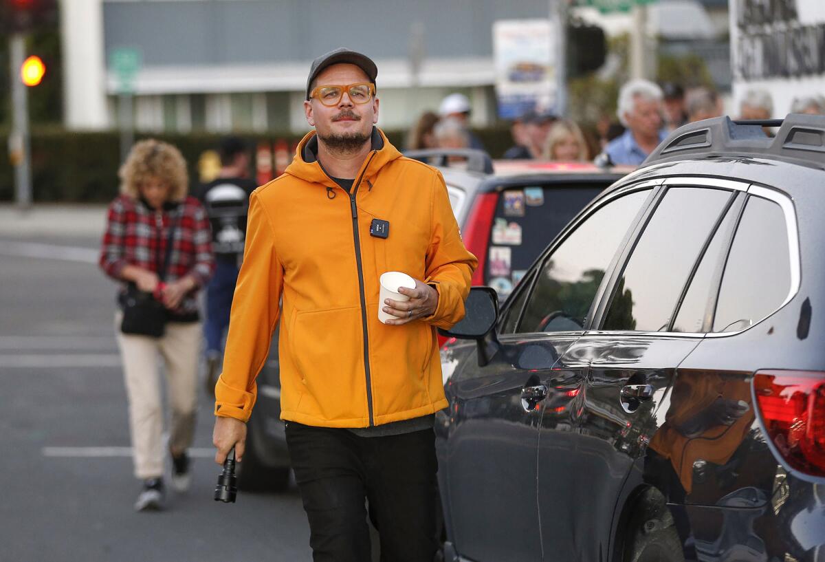 Artist Cristopher Cichocki walks to his featured exhibit in Laguna Beach.