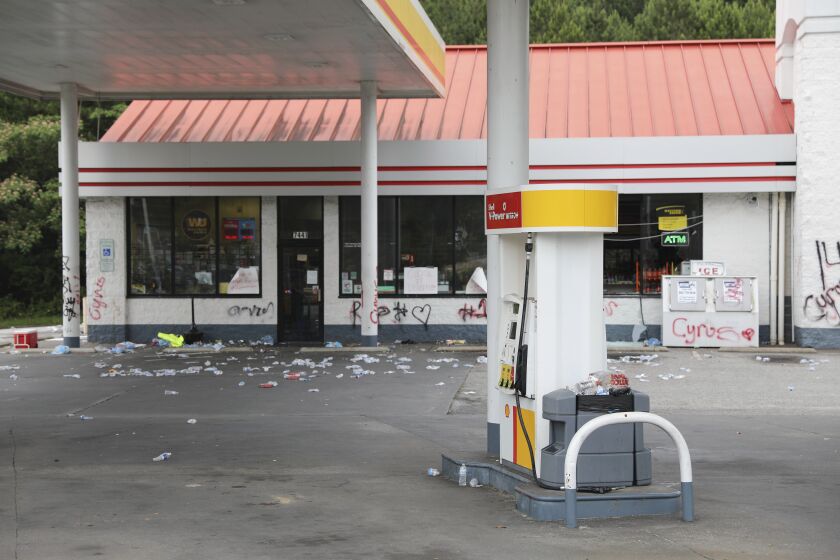 Debris is spread out in front of a convenience store, Tuesday, May 30, 2023, in Columbia, S.C. Richland County deputies said the store owner chased a 14-year-old he thought shoplifted, but didn't steal anything and fatally shot the teen in the back. (AP Photo/Jeffrey Collins)