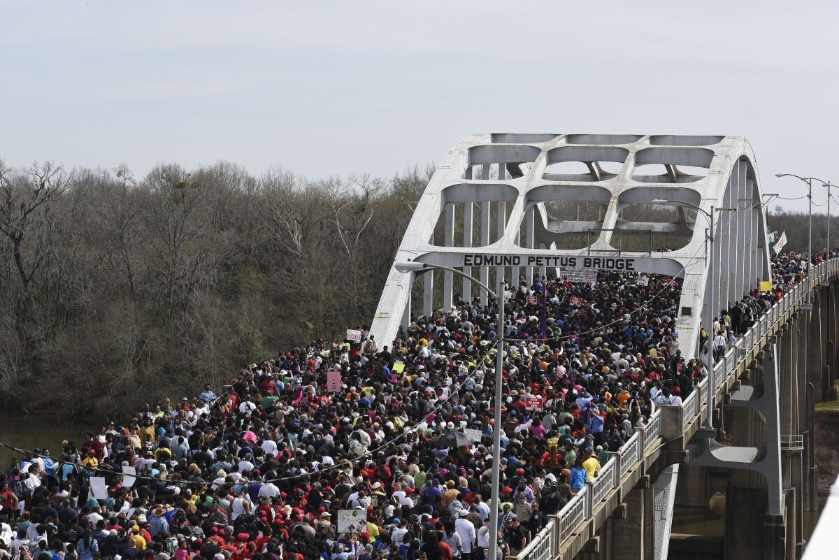 Crowds take a symbolic walk across the Edmund Pettus Bridge on Sunday in Selma, Ala.