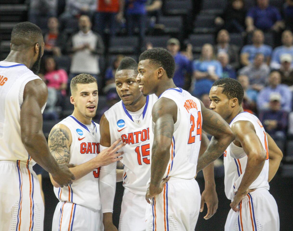 Florida players Patric Young (4), Scottie Wilbekin (5), Will Yeguete (15), Casey Prather (24), and Kasey Hill (0) react as time runs down sealing their 79-68 victory over UCLA in an NCAA sweet sixteen southern region semifinal basketball game at the FedEx Forum in Memphis, TN.
