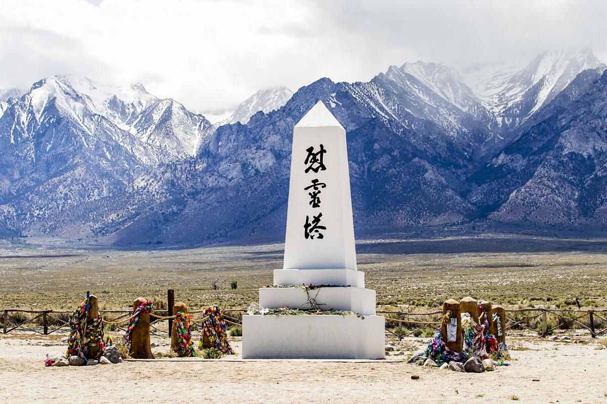 Cemetery monument with Japanese characters, with mountains in the background