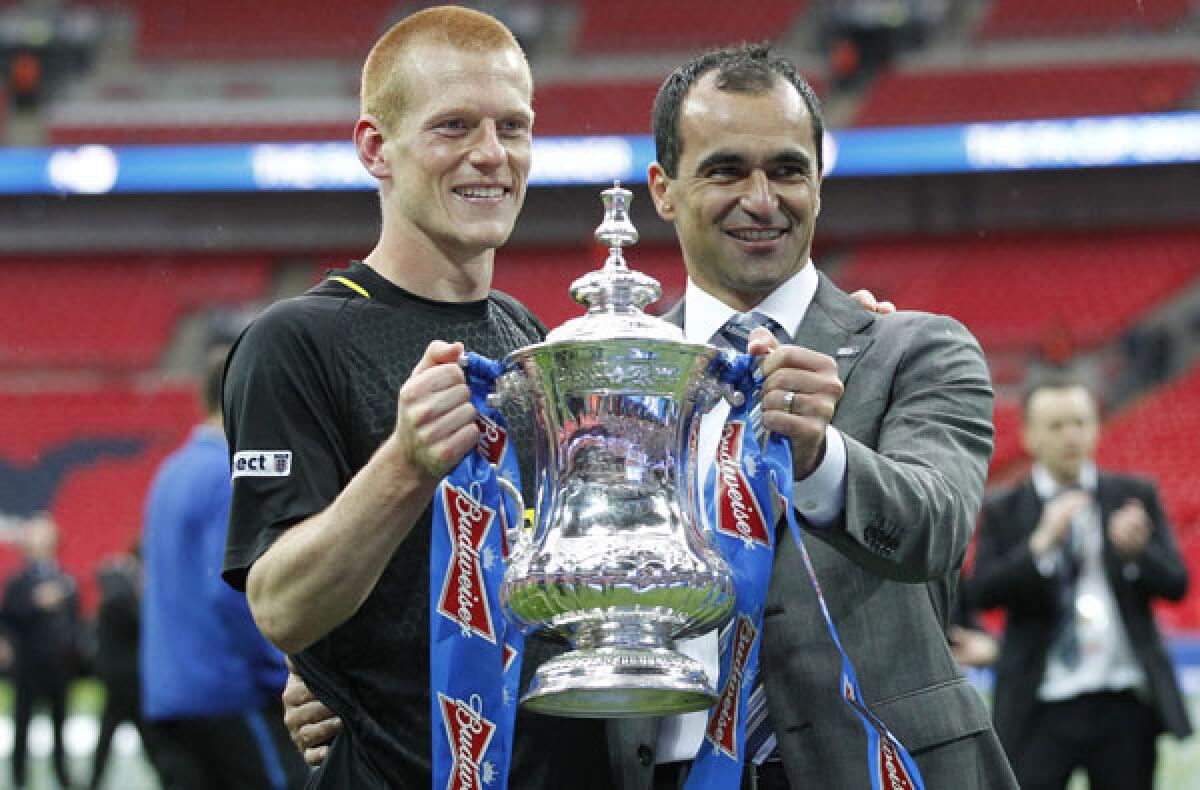 Wigan midfielder Ben Watson and Manager Roberto Martinez pose with the FA Cup after a 1-0 victory over Manchester City in the final on Saturday at Wembley Stadium.