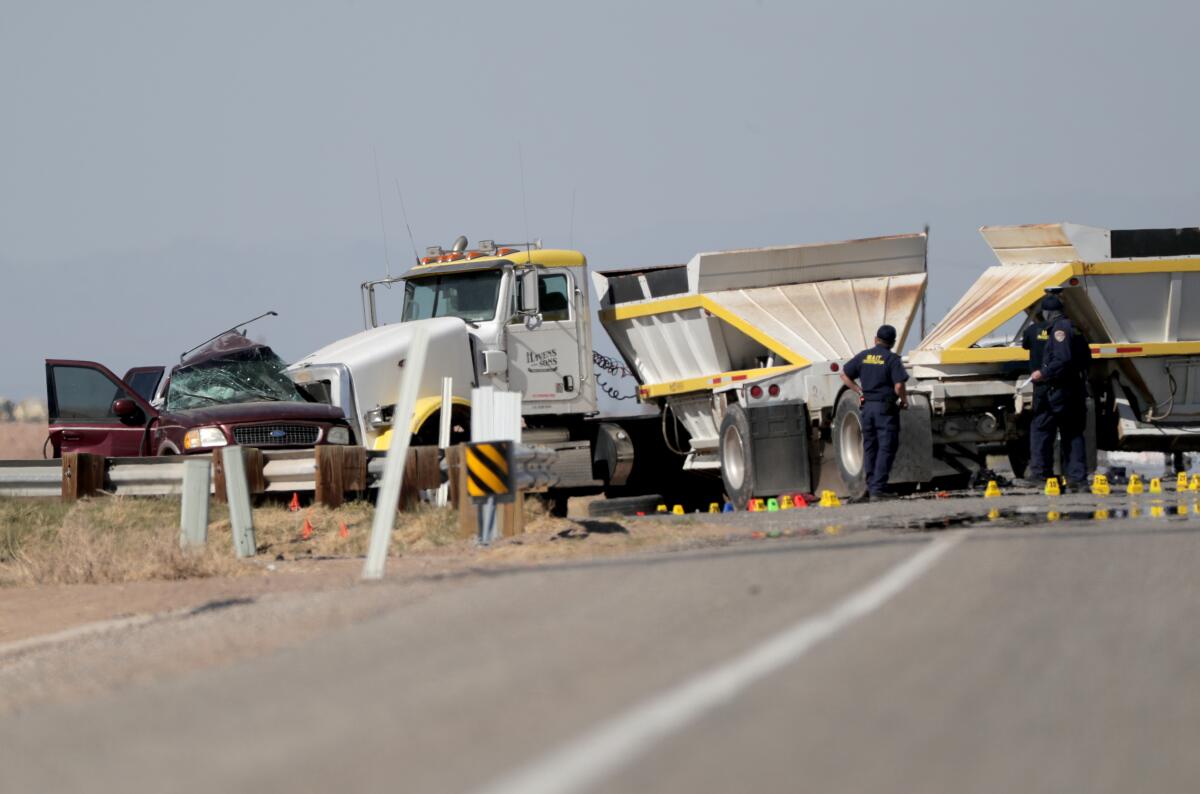 A smashed SUV sits beside a tractor-trailer in Holtville, Calif.