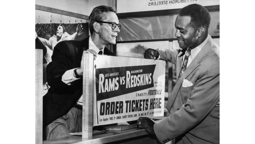 Former Los Angeles Ram Kenny Washington purchases ticket charity football game from Bill John, Rams business manager.