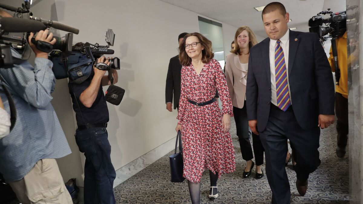 Gina Haspel, center, who is President Trump's nominee to lead the CIA, walks past TV cameras as she heads to a meeting on Capitol Hill on Monday.