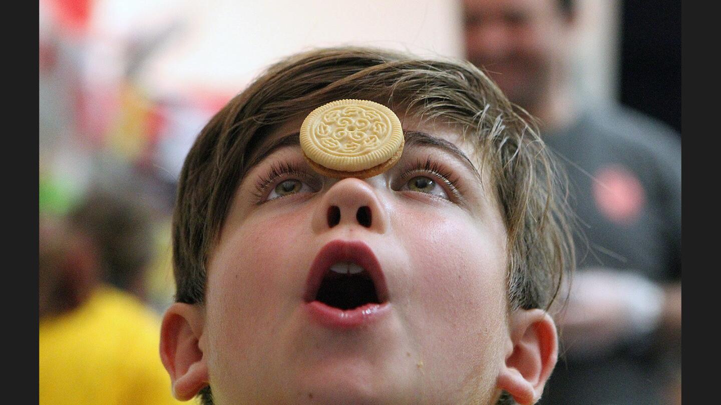 Lyons Mathias, 9, tries to move a cookie from his forehead to his mouth in the "kooky faces" event at the 13th annual mother and son Olympics, put on by the Dad's Club at Abraham Lincoln Elementary School in Glendale on Friday, October 14, 2016. Lyons had no luck moving a cookie to his mouth.