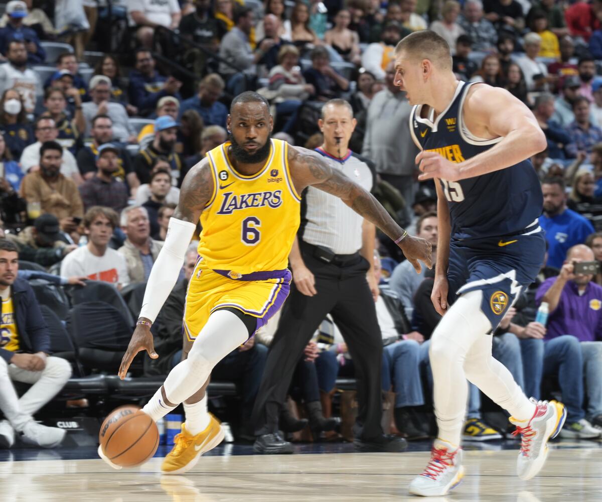 LeBron James drives against Nikola Jokic during a game last October.