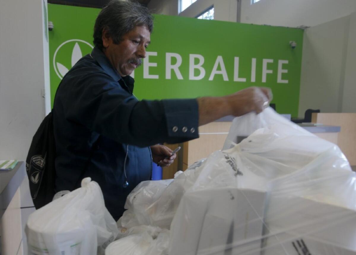 Herbalife distributor Jaime Ayala picks up some products at a distribution center in Carson earlier this year.