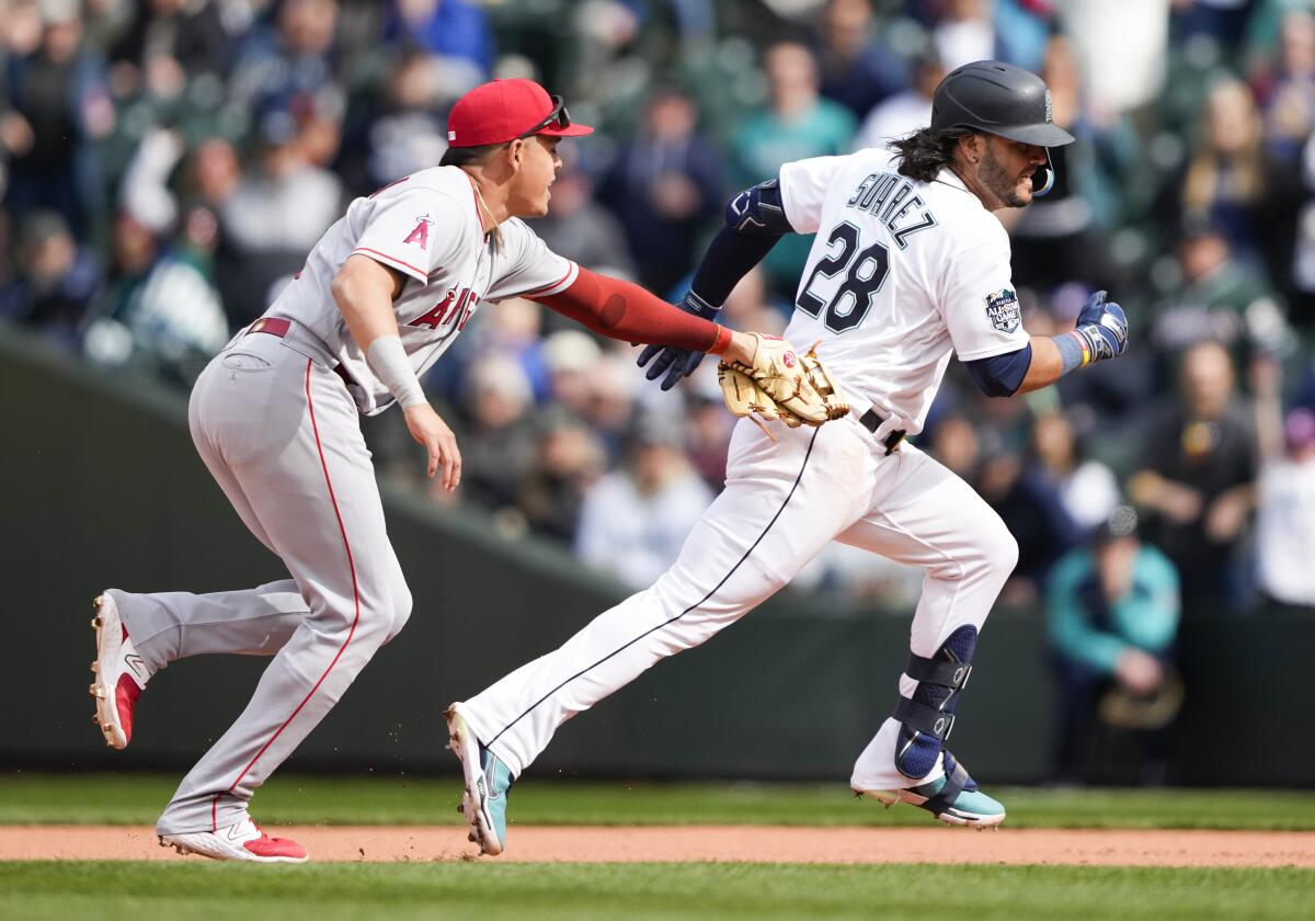 Angels third baseman Gio Urshela tags out Seattle Mariners' Eugenio Suarez during a rundown after Suarez hit an RBI single.