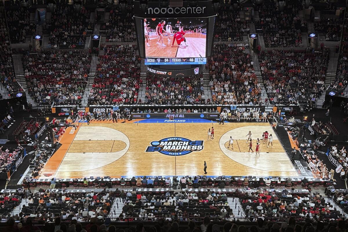 A full court, bird's eye view of Texas and North Carolina State playing during an Elite Eight college basketball game.