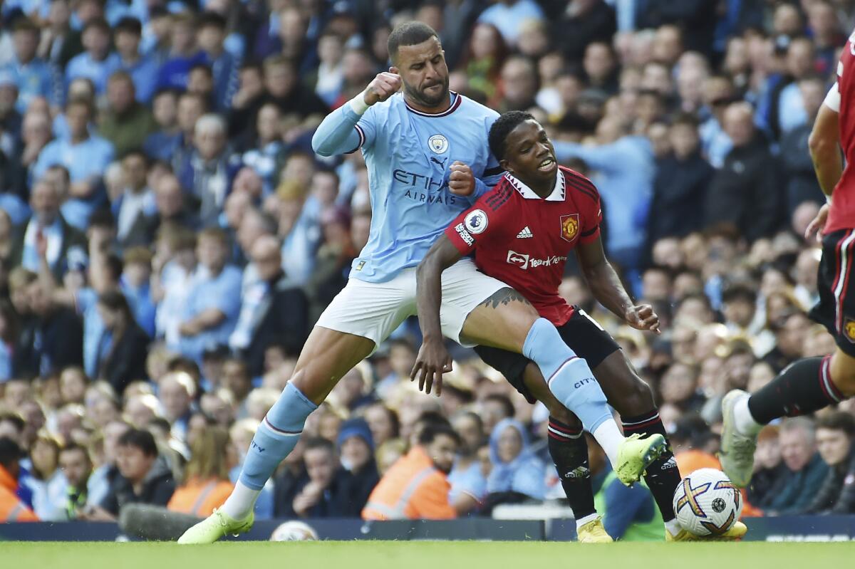 Manchester City's Kyle Walker, left, challenges for the ball with Manchester United's Tyrell Malacia during the English Premier League soccer match between Manchester City and Manchester United at Etihad stadium in Manchester, England, Sunday, Oct. 2, 2022. (AP Photo/Rui Vieira)
