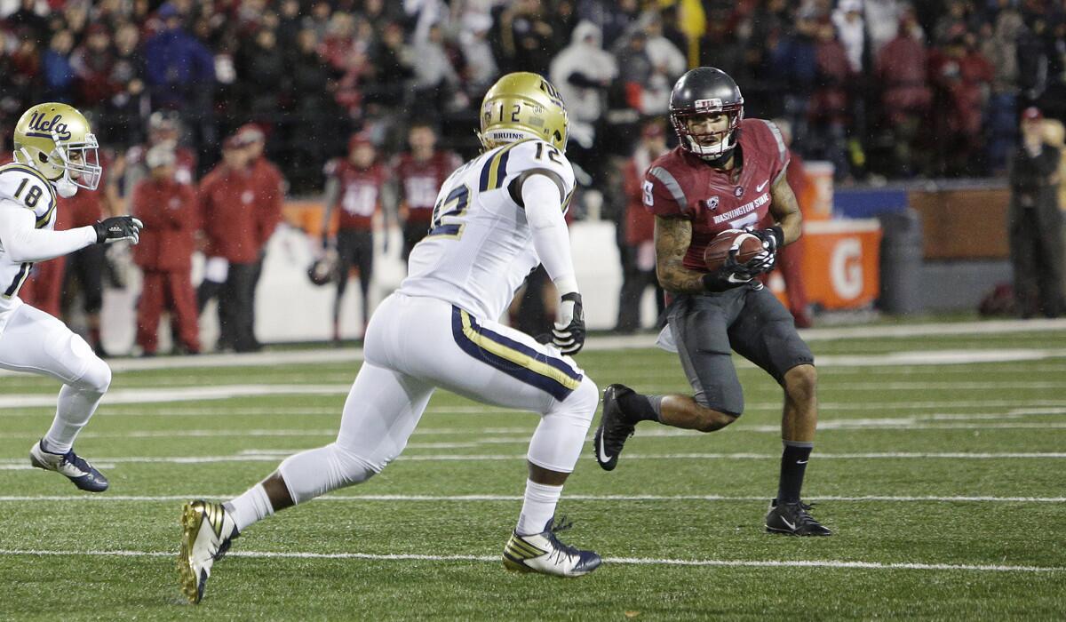 Washington State wide receiver Gabe Marks (9) runs with the ball while pursued by UCLA linebacker Jayon Brown (12) during the first half Saturday.