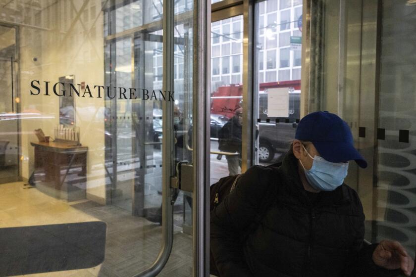 A person leaves one of the Signature Bank branches in New York, Monday, March. 13, 2023. President Joe Biden is telling Americans that the nation’s financial systems are sound. This comes after the swift and stunning collapse of two banks that prompted fears of a broader upheaval. (AP Photo/Yuki Iwamura)