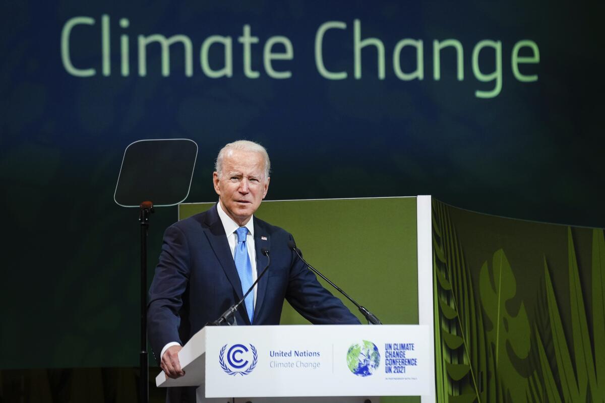 President Biden stands at a lectern in front of a banner with the words "Climate change."