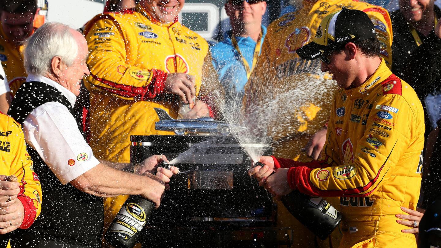 Joey Logano, right, celebrates with team owner Roger Penske after winning the Daytona 500 on Feb. 22, 2015.