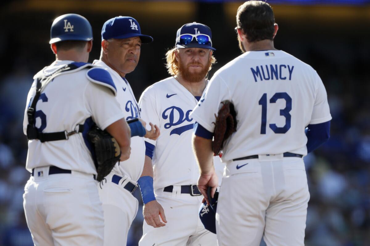 Dodgers manager Dave Roberts meets with catcher Will Smith, third baseman Justin Turner and first baseman Max Muncy.