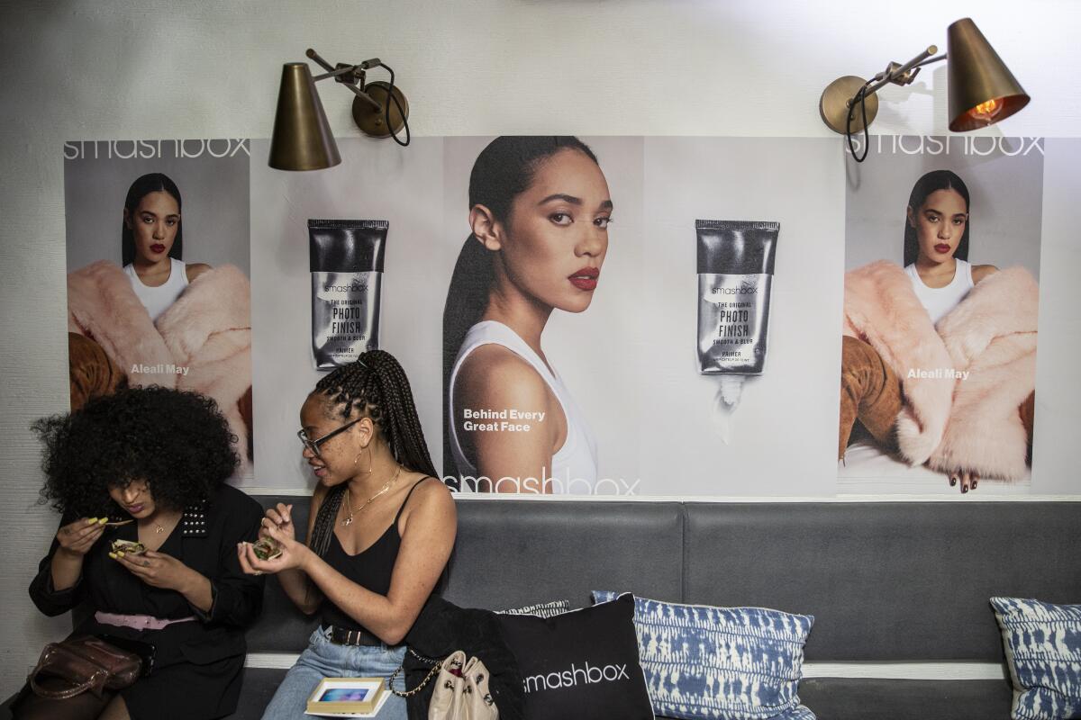 Model Salem Mitchell, right, shares a snack with a friend during a Smashbox party in honor of Aleali May becoming the new face for the makeup brand's Original Photo Finish Smooth & Blur Primer on April 17, 2019.