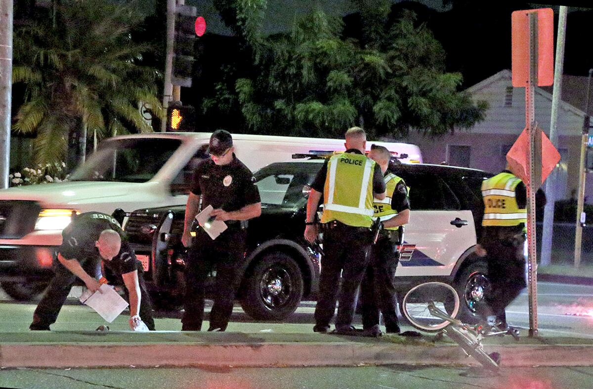 Burbank police traffic investigators analyze the scene of a vehicle collision near the intersection of Alameda Avenue and Lake Street on Thursday after a 16-year-old bicyclist was struck by a vehicle and suffered serious injuries. 