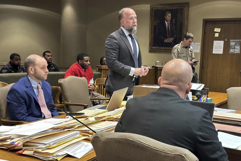 Lawyer Luke Evans, center, discusses a change of venue motion with a judge as his client Justin Johnson, back, looks on during a hearing in the 2021 slaying of rapper Young Dolph on Friday, Feb. 2, 2024, in Memphis, Tenn. (AP Photo/Adrian Sainz)