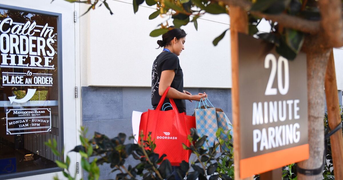 DoorDash deliverer Ricky Sierra picks up an order at Mendocino Farms in El Segundo.