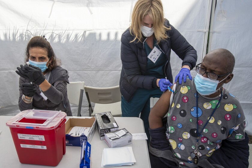 California isn't seeing COVID-19 spikes like New York and
Florida. Can we keep it up? 3 LOS ANGELES, CA - MARCH 18: Los Angeles resident Henry Fredricks, 62, right, prepares to get a vaccine from RN Nili Steiner, center at Karsh Family Social Service Center pop-up clinic for older adults in the neighborhood on Thursday, March 18, 2021 in Los Angeles, CA. Pharmacist Nasrin Assil fills syringes with vaccine, left. (Brian van der Brug / Los Angeles Times)