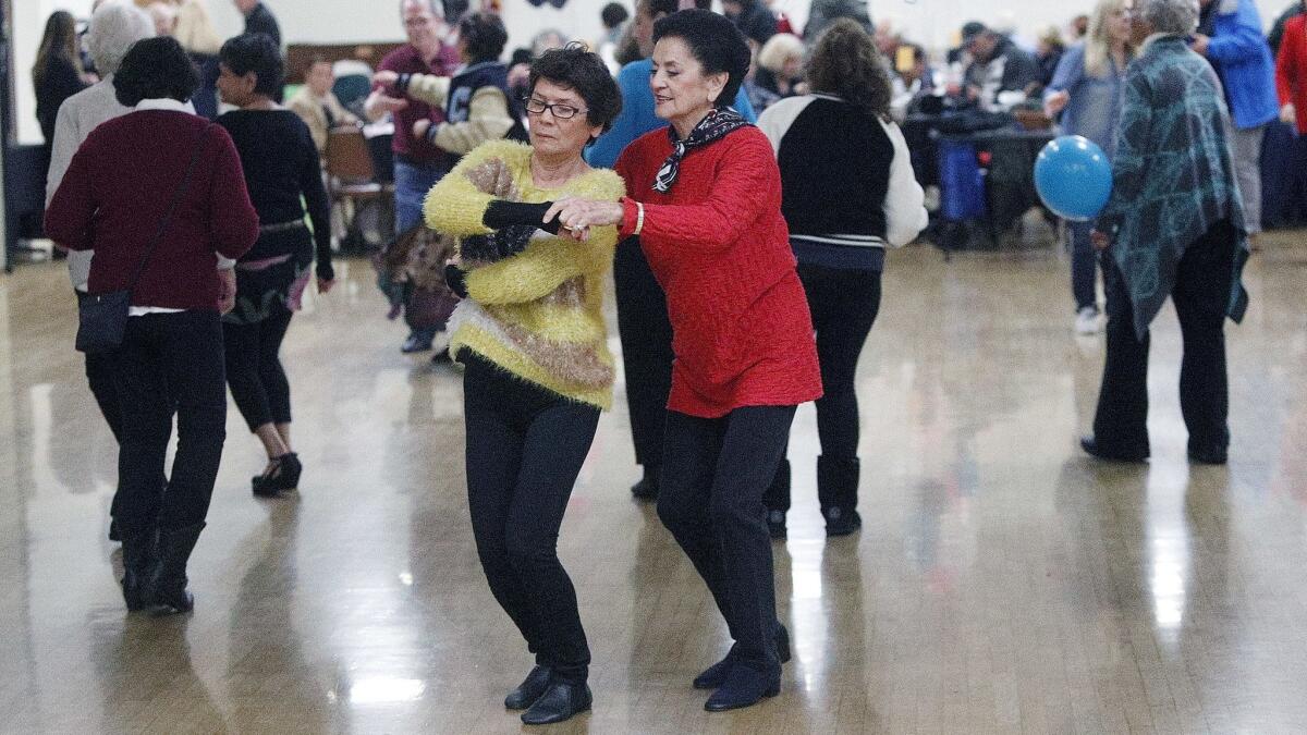 Lilly Chen, of North Hollywood, and Rikki Varton, of Burbank, dance together at a sock hop, one of several rotating dance opportunities for seniors at the Joslyn Adult Center in Burbank on Monday.