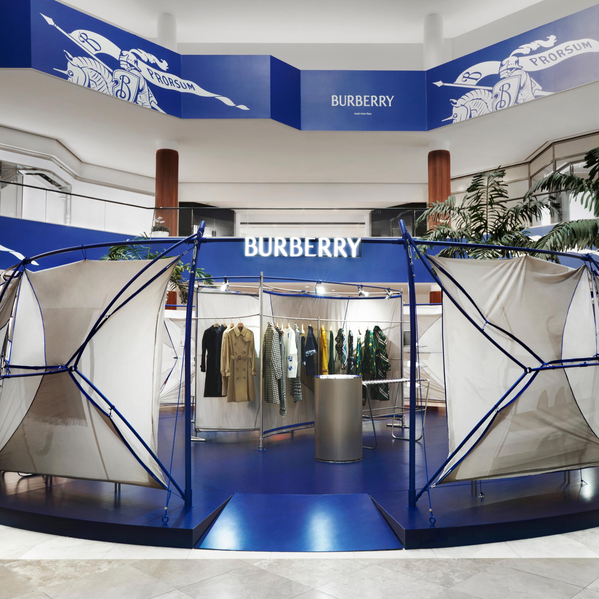 A space that mostly blue and white with clothing on a rack.