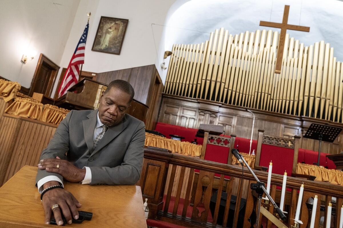 El reverendo Jimmie Hardaway Jr. muestra la pistola que lleva consigo durante los servicios en la Iglesia 