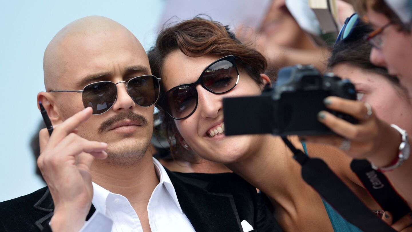 US actor and director James Franco poses for a selfie with fans as he arrives for the screening of the movie "The Sound and the Fury" presented out of competition at the 71st Venice Film Festival on September 6, 2014 at Venice Lido.