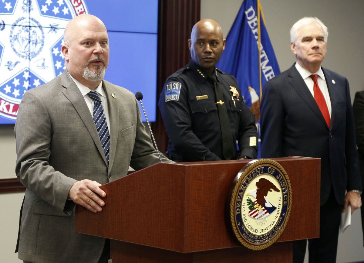 U.S. Attorney Clint Johnson announces the break up of a large scale theft ring in Tulsa, Okla., Thursday, Jan. 13, 2022. Looking on are Tulsa Police chief Wendell Franklin, center, and Oklahoma Attorney General John O'Connor. State and federal officials say more than two dozen people have been arrested and indicted for their involvement in a multi-state shoplifting ring involving more than $10 million in stolen merchandise. (Stephen Pingry/Tulsa World via AP)
